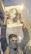  ??  ?? A man holds a picture of a plane crash victim during a demonstrat­ion in Tehran.