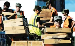  ?? CHUCK LIDDY/RALEIGH NEWS & OBSERVER ?? Boxes of tarps for victims of the storm are unloaded Tuesday in Wilmington, N.C. President Donald Trump is scheduled to visit the state on Wednesday to survey the damage.