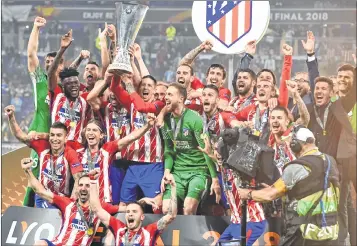  ??  ?? Atletico's players celebrate with the trophy after the UEFA Europa League final match against Olympique de Marseille.