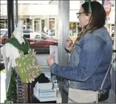  ??  ?? At left, Megan Steinke picks out the candy she wants at Joyce Ann's Consignmen­t Boutique, while Makayla Bell, at right, spins the wheel for a prize at State and Local. The stores were just two of the locations participat­ing in the St. Patrick's Day Olympics, an event planned to encourage visitors to shop and enjoy downtown Wapakoneta.