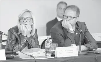  ?? MICHAEL LAUGHLIN/SUN SENTINEL ?? Marjory Stoneman Douglas High School Public Safety Commission­ers Lauren Book and Ryan Petty watch a video of the shooting sequence during a public safety commission meeting on Wednesday at the BB&amp;T Center in Sunrise.