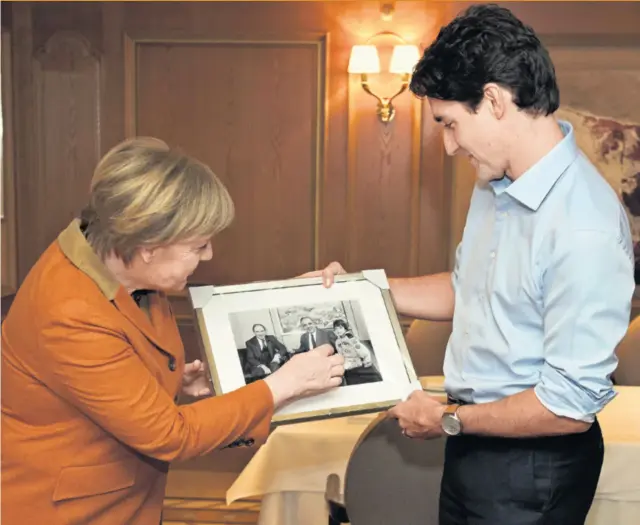  ??  ?? Angela Merkel poklonila je Justinu Trudeauu fotografij­u na kojoj je, kao 11-godišnji dječak 1982., u pratnji oca za posjeta kancelaru Kohlu u Bonnu