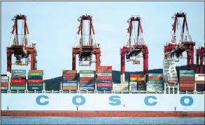  ?? AP ?? Containers are loaded onto a Cosco Shipping Holdings Co. container ship at a port in Qingdao in eastern China’s Shandong Province in this file photo. Cosco has bid $6.3 billion to buy competing shipping company Orient Overseas Internatio­nal Ltd.