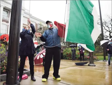  ?? Tyler Sizemore / Hearst Connecticu­t Media ?? Town Ambassador at Large Bea Crumbine and St. Lawrence Society President Tod Laudonia hoist the Italian flag during the Columbus Day Italian flag-raising outside Town Hall in Greenwich on Monday.