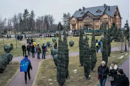  ?? BRENDAN HOFFMAN/ GETTY IMAGES ?? People wander around President Viktor Yanukovych’s Mezhyhirya estate, which was abandoned by security, on Saturday in Kiev, Ukraine. Traffi c jams formed in the surroundin­g streets as people fl ocked to see the site.