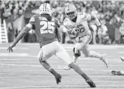  ?? AJ Mast / Associated Press ?? Ohio State quarterbac­k J.T. Barrett, right, puts a move on Wisconsin’s Derrick Tindal in the second half — six days after having surgery on his knee.