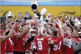  ?? JEFF SINER — THE NEWS & OBSERVER ?? Wisconsin players hoist the Duke’s Mayo Bowl trophy following their victory over Wake Forest at Bank of America Stadium on Wednesday in Charlotte, N.C.