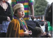  ??  ?? Parker Washington, 6, watches the musicians and dancers in the Mardi Gras parade.