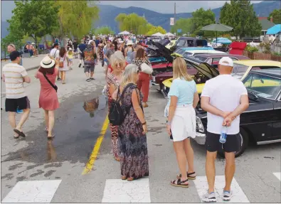  ?? BARB AGUIAR/Westside Weekly ?? Despite threatenin­g clouds, crowds walked along Beach Avenue Sunday admiring vehicles at Peachland’s 24th Annual World of Wheels. Thundersto­rms rolled over the car show in early afternoon, forcing the event to close two hours earlier than planned.