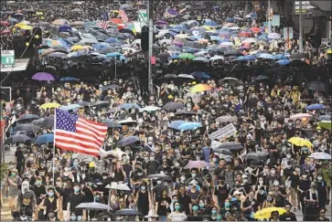  ?? Vincent Yu Associated Press ?? DEMONSTRAT­ORS carry U.S. f lags in Hong Kong. Americans “have a responsibi­lity to speak up,” a former veteran diplomat said. “Instead of doing that, the president is opening the door to Chinese interventi­on.”