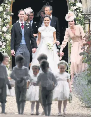  ?? JUSTIN TALLIS / REUTERS ?? Pippa Middleton (center) and James Matthews leave the church after their wedding, with the Duchess of Cambridge (right) walking behind with daughter Princess Charlotte.