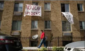  ?? (AP/Andrew Harnik) ?? Signs reading “no job no rent” hang from an apartment building last month in Washington.