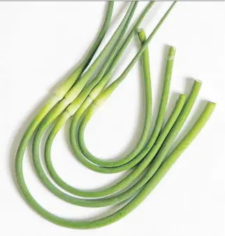  ?? DARREN BROWN/ OTTAWA CITIZEN ?? Garlic scapes are shoots from some types of garlic. Farmers trim them so they won’t drain nutrients from the garlic bulb. You can find recipes for everything from scape lasagna to stir-fries.