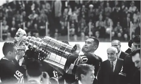  ?? BOB OLSEN TORONTO STAR FILE PHOTO ?? Captain George Armstrong, right, passes on the Stanley Cup after the Toronto
Maple Leafs won the Stanley Cup on May 2, 1967. Armstrong, who captained the Leafs when they held their training camps in Peterborou­gh, died Sunday at age 90.