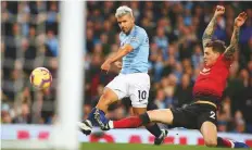  ?? AP ?? Manchester City’s Sergio Aguero shoots past Manchester United’s Victor Lindelof to score his team’s second goal