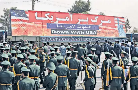  ?? ?? An anti-american banner is displayed during a military parade outside Tehran commemorat­ing the start of the Iran-iraq war on Sept 22 1980