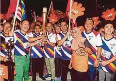  ??  ?? AMINUDDIN (tengah) membawa obor Kuala Lumpur 2017 untuk diserahkan kepada Ahmad Bashah.