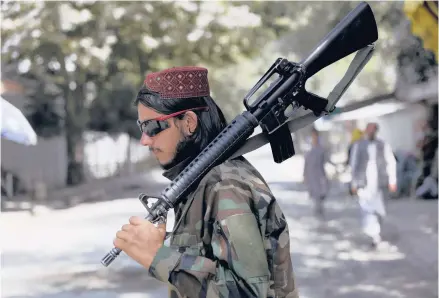  ?? RAHMAT GUL/AP ?? A Taliban fighter stands guard at a checkpoint in the Wazir Akbar Khan neighborho­od in Kabul, Afghanista­n.