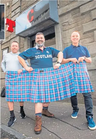  ??  ?? From left: Scott Clark, Tom Urie and Gus Robb with the kilt that used to fit Tom before he lost weight.