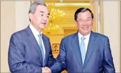  ?? AFP ?? Chinese Foreign Minister Wang Yi (left) shakes hands with Prime Minister Hun Sen upon his arrival at the Peace Palace in Phnom Penh in 2016.