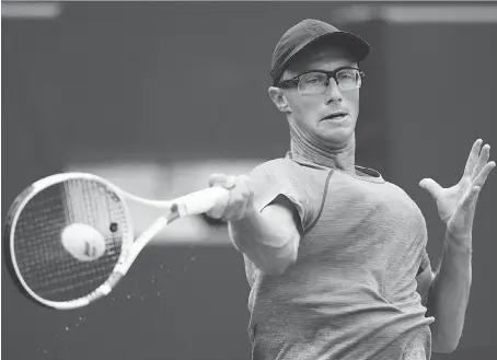  ?? MARK BLINCH/THE CANADIAN PRESS ?? Canadian Peter Polansky returns a shot to Novak Djokovic of Serbia at the Rogers Cup at the Aviva Centre in Toronto on Wednesday. The native of nearby Thornhill lost the second-round match 6-3, 6-4.