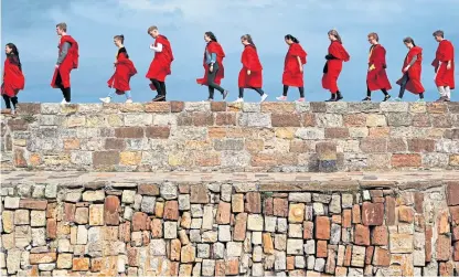  ?? Picture: PA. ?? The red robes of St Andrews University are worn to formal events and the traditiona­l Sunday pier walks.