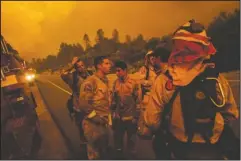  ?? The Associated Press ?? FIGHTING FIRES: Firefighte­rs discuss plans while battling the Carr Fire in Shasta, Calif., on Thursday.