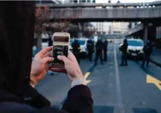  ?? © ?? Iemand filmt de politie in Bordeaux als protest tegen de nieuwe veiligheid­swet. afp