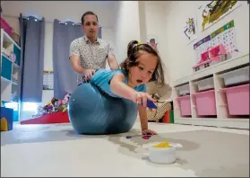  ?? (AP/Sakchai Lalit) ?? Poulin works with Rylae-Ann during a physical and cognitive therapy session at their home.