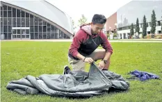  ?? COLLIN BINKLEY/THE ASSOCIATED PRESS ?? Vick Liu unrolls his TravlerPac­k, a lightweigh­t sleeping bag, outside the Kresge Auditorium at the Massachuse­tts Institute of Technology.