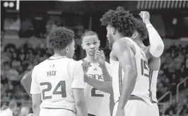  ?? GREGORY FISHER USA TODAY NETWORK ?? Hurricanes guards Nijel Pack and Isaiah Wong (2) and forward Norchad Omier (15) talk during a timeout in the second half of their win against the Drake Bulldogs.