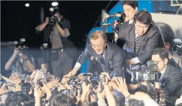  ?? AP ?? In this May 10 photo, then presidenti­al candidate Moon Jae-in of the Democratic Party is greeted by supporters as he arrives to give a speech on a stage in Seoul.