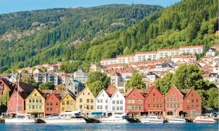  ?? RICK STEVES ?? The colorful and somewhat tipsy old wooden commercial buildings of Bryggen on Bergen’s harborfron­t in Norway.