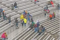  ?? MATT BELL/THE ASSOCIATED PRESS ?? The few fans who braved the weather leave Saturday after rain canceled the NASCAR Trucks Series race at Martinsvil­le Speedway in Martinsvil­le, Va.