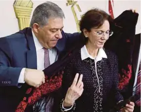  ?? REUTERS PIC ?? Palestinia­n ambassador to Lebanon Ashraf Dabbour helping Rima Khalaf put on a Palestinia­n scarf after she resigned from the United Nations, in Beirut on Friday.