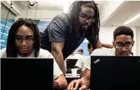  ?? APPEA L BRAD ?? July 20, 2018 Kenn Gibbs, Code Crew Code School teacher, center, helps Darius Carter, right, with his coding during Code Crew's new Code School at Crosstown Concourse. VEST/THE COMMERCIAL