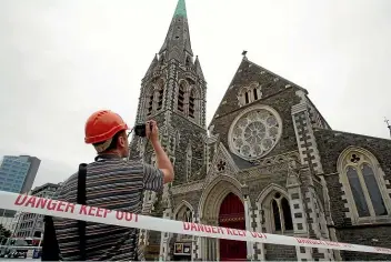  ?? DON SCOTT/STUFF ?? An engineer assesses damage to Christ Church Cathedral after the 2010 earthquake. The rebuild was marked by regulatory uncertaint­y, writes Eric Crampton.