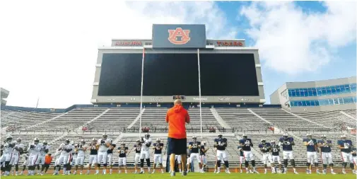  ?? AUBURN ATHLETICS PHOTO BY TODD VAN EMST ?? Auburn football players warm up before their first preseason scrimmage on Aug. 22. The Tigers have not practiced since last Tuesday due to coronaviru­s concerns and have at least 16 players who are out this week.