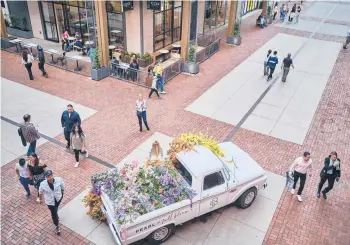  ?? WILLIAM DESHAZER/THE NEW YORK TIMES ?? People mill around 5th + Broadway, a complex of restaurant­s and shops in downtown Nashville, Tennessee, on April 12.