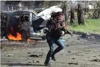  ?? ALJAZEERA ?? MASIH MENGGENGGA­M KAMERA: Abd. Alkader Habak berlari sambil membopong salah satu korban bom di Syria.