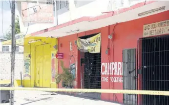  ?? NICHOLAS NUNES PHOTOS ?? Crime scene tape cordons the bar where businessma­n Robert Fletcher was killed in the Swallowfie­ld area of St Andrew yesterday. Cops later intercepte­d the suspected getaway car and killed two gunmen following a confrontat­ion.