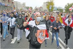  ?? AP PHOTO/TUT.BY ?? Demonstrat­ors, one of them wearing an old Belarusian nation flag and holding a cardboard sword reading “solidarity,” march during an opposition rally Sunday to protest the official presidenti­al election results in Minsk, Belarus.