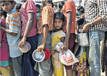  ??  ?? Rohingya people wait in line to receive food aid at Kutupalong refugee camp, near Cox’s Bazar, Bangladesh