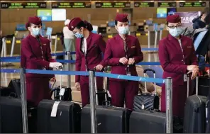  ?? (AP/Marcio Jose Sanchez) ?? Flight attendants wait to check in luggage Wednesday at Los Angeles Internatio­nal Airport. Despite warnings from public health officials, millions of Americans are traveling for the holidays. More photos at arkansason­line.com/1224airpor­t/.