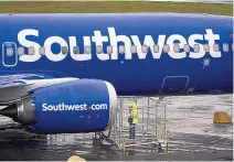  ?? TED S. WARREN/ASSOCIATED PRESS ?? A worker uses a flashlight to inspect an engine on a Boeing 737 Max 8 built for Southwest Airlines at Renton Municipal Airport in Renton, Wash. On Monday, Southwest said it’s expanding its allBoeing fleet with an order for 100 737 MAX airplanes.