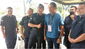  ?? ?? Man of the hour: Kampung baru subang police station personnel posing for photograph­s with Khairy during his visit.