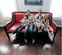  ??  ?? Kamil Issa and his family in the sitting room of their new Glenora home on a red leather bench sofa.