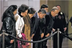  ??  ?? Mourners bow three times in the City Hall rotunda to honor San Francisco’s first Chinese American mayor. The atmosphere inside City Hall was especially hushed.