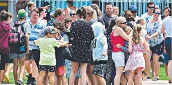  ?? EMOTIONAL: Students and family are reunited at Willows State School yesterday. Picture: ZAK SIMMONDS ??