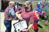  ?? Dan Watson/The Signal ?? Santa Clarita City Councilwom­an Laurene Weste, left, elbow-bumps Kiz Bunkell as Bunkell receives her third-place certificat­e during the city’s 2020 Fourth of July Patriotic Tour on Saturday.